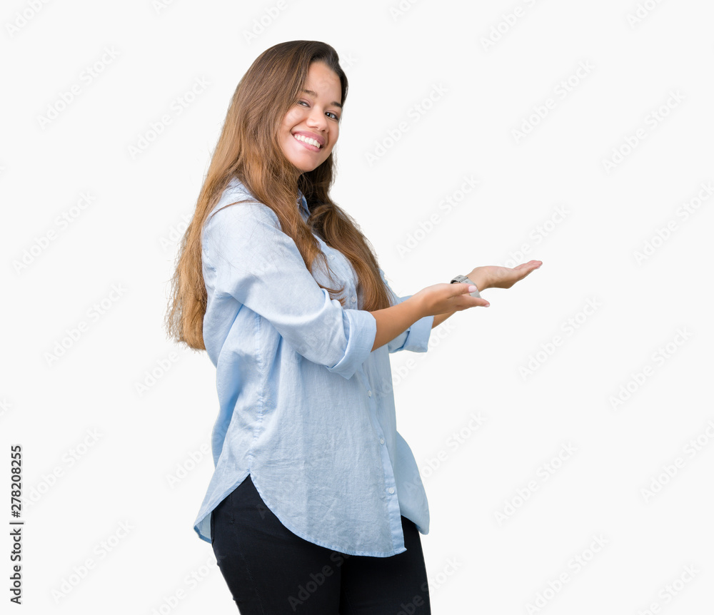 Young beautiful brunette business woman over isolated background Inviting to enter smiling natural with open hand Young beautiful brunette business woman over isolated background Inviting to enter smiling natural with open hand