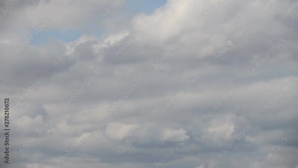 Time interval. Clouds are floating against the blue sky. The wind drives clouds across the sky