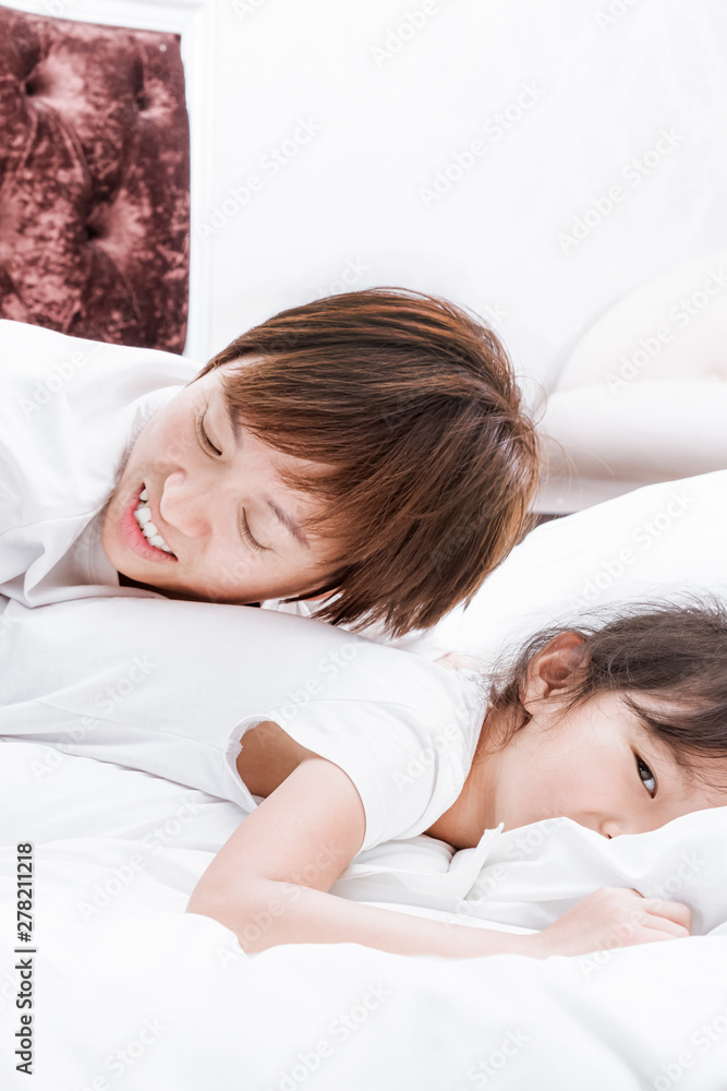 Mothers and daughters in white shirts lie on their beds playing Mothers and daughters in white shirts lie on their beds playing