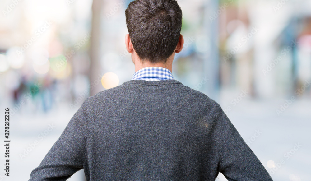 Young handsome smart man wearing glasses over isolated background standing backwards looking away with arms on body Young handsome smart man wearing glasses over isolated background standing backwards looking away with arms on body