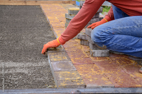 A worker is laying paving slabs