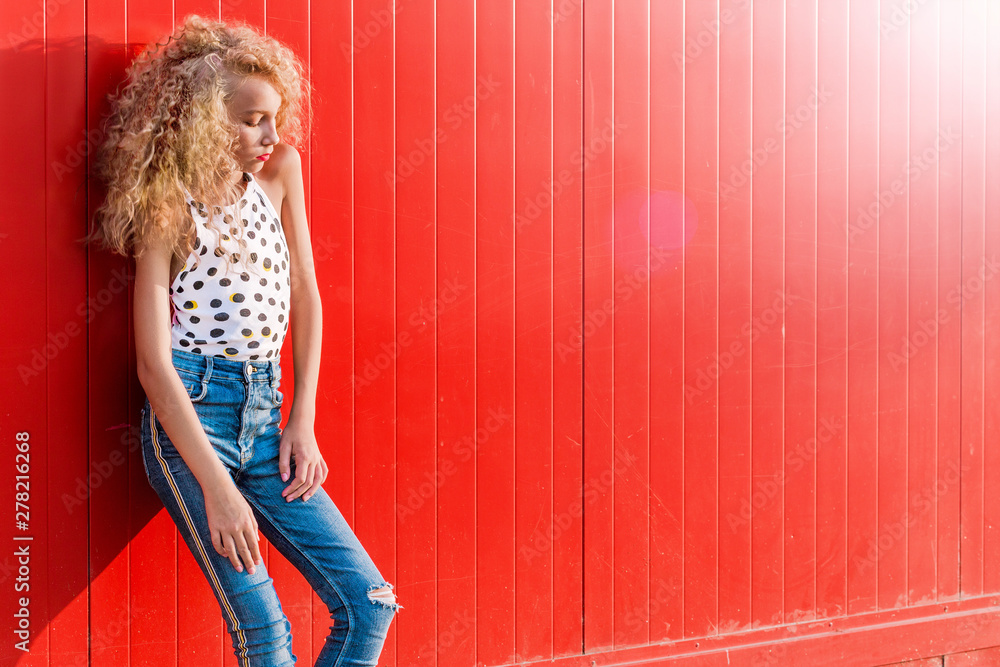 teen girl posing on red wall background