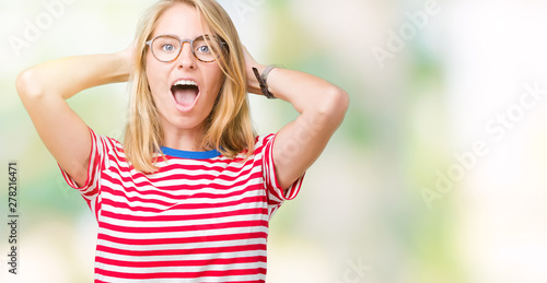 Beautiful young woman wearing glasses over isolated background Crazy and scared with hands on head, afraid and surprised of shock with open mouth