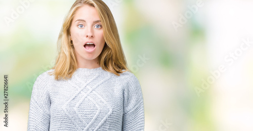 Beautiful young woman wearing winter sweater over isolated background afraid and shocked with surprise expression, fear and excited face.