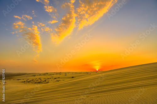 Sun at sunset over sand dunes at Inland Sea. Desert landscape near Qatar and Saudi Arabia. Khor Al Udeid, Persian Gulf, Middle East. Discovery and adventure travel concept. © bennymarty