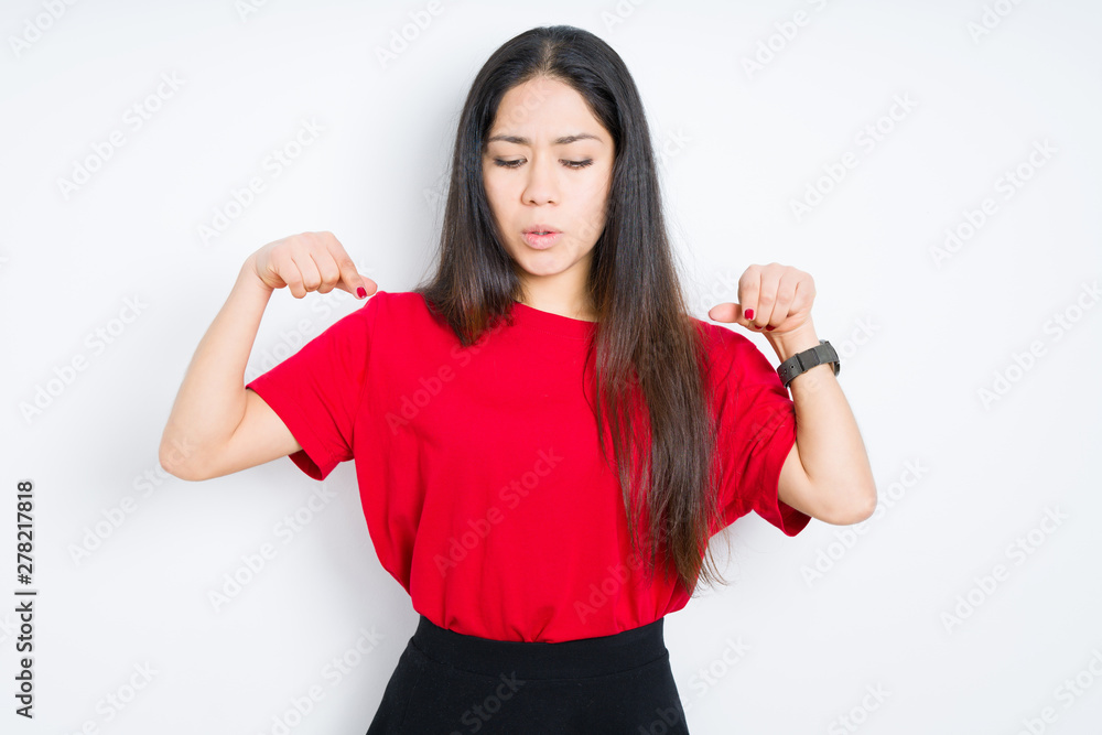 Beautiful brunette woman wearing red t-shirt over isolated background Pointing down with fingers showing advertisement, surprised face and open mouth Beautiful brunette woman wearing red t-shirt over isolated background Pointing down with fingers showing advertisement, surprised face and open mouth