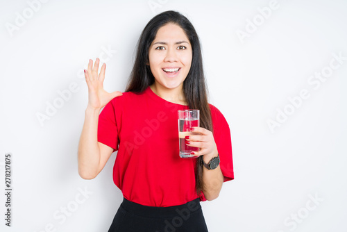 Tableau sur toile Young brunette woman drinking a glass of water over isolated background very hap