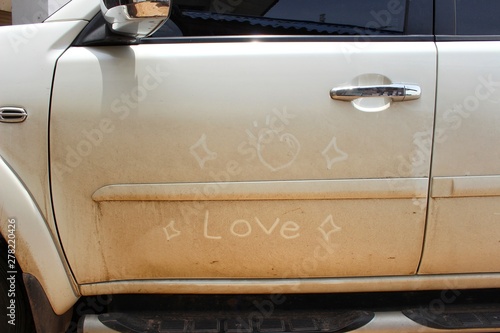 The white car has a heart shape and the words love on the car door, take a blurred picture