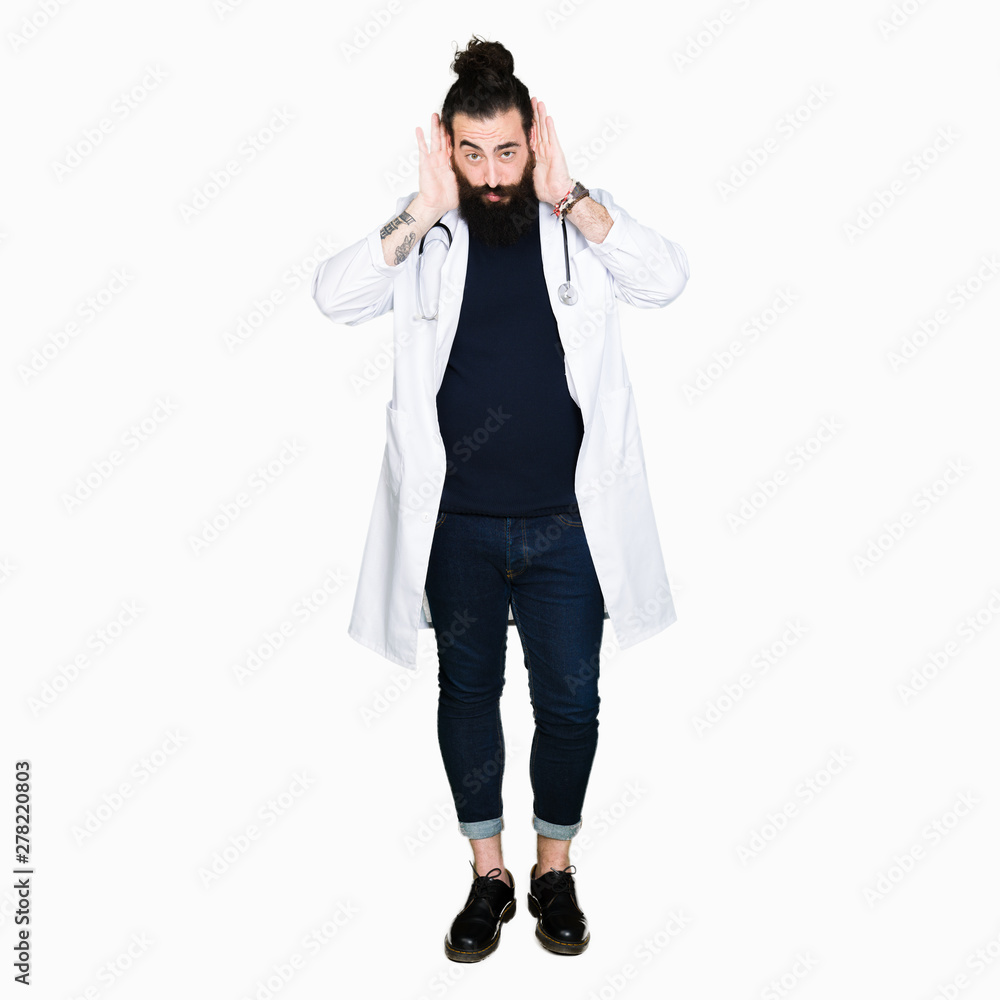 Doctor with long hair wearing medical coat and stethoscope Trying to hear both hands on ear gesture, curious for gossip. Hearing problem, deaf Doctor with long hair wearing medical coat and stethoscope Trying to hear both hands on ear gesture, curious for gossip. Hearing problem, deaf