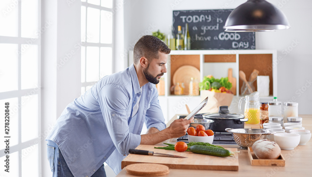 Smiling and confident chef standing in large kitchen Smiling and confident chef standing in large kitchen