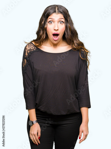 Foto Beautiful young woman with long hair afraid and shocked with surprise expression, fear and excited face