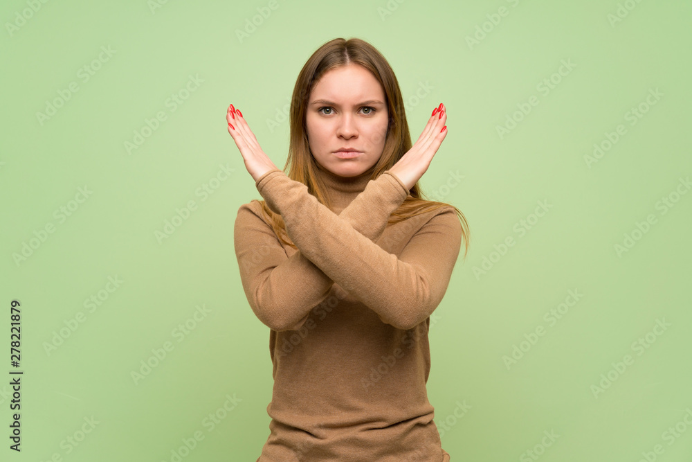 Young woman with turtleneck sweater making NO gesture Young woman with turtleneck sweater making NO gesture