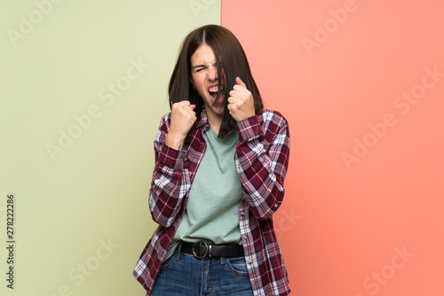 Young woman over isolated colorful wall frustrated by a bad situation © luismolinero