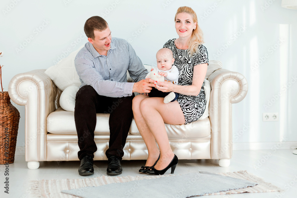 Family time. Dad and mom are sitting on the couch with their young son Family time. Dad and mom are sitting on the couch with their young son