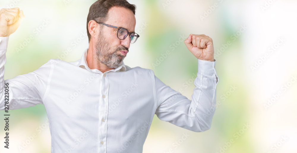 Naklejka premium Handsome middle age elegant senior business man wearing glasses over isolated background showing arms muscles smiling proud. Fitness concept.