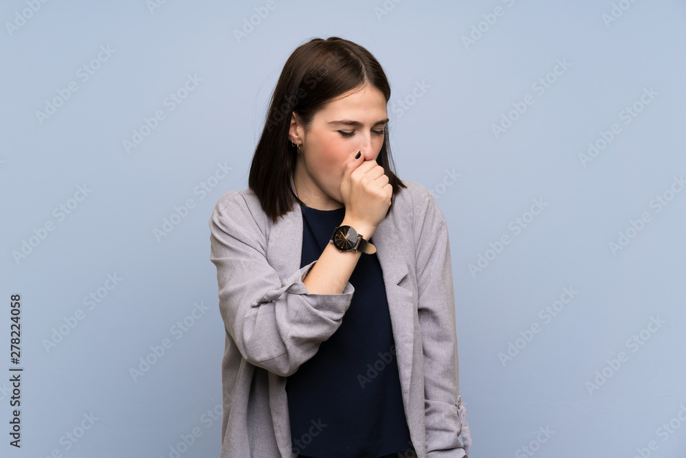 Young woman over isolated blue wall is suffering with cough and feeling bad Young woman over isolated blue wall is suffering with cough and feeling bad