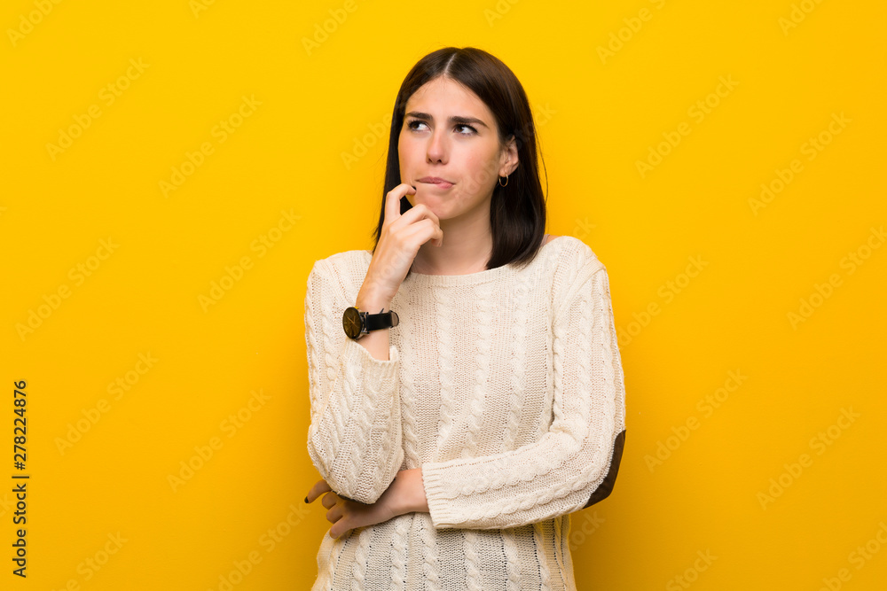 Young woman over isolated yellow wall with confuse face expression Young woman over isolated yellow wall with confuse face expression