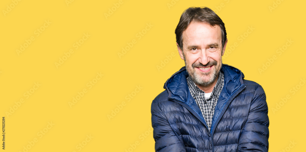 Middle age handsome man wearing winter coat Smiling with hands palms together receiving or giving gesture. Hold and protection Middle age handsome man wearing winter coat Smiling with hands palms together receiving or giving gesture. Hold and protection