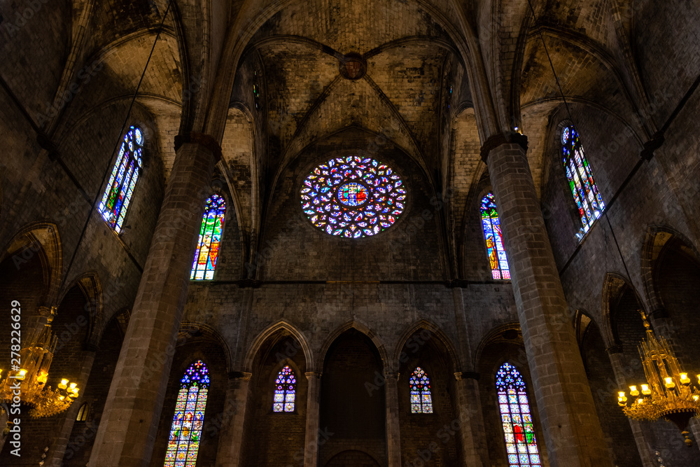 Interior of Santa Maria del Mar Basilica in typical Catalan Gothic style with pointed arches and high columns. Detail of the colourful rose window. La Ribera. Barcelona.