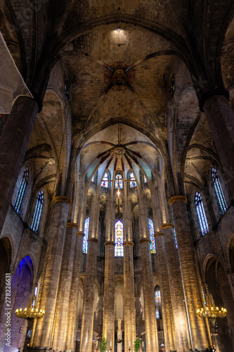 Interior of Santa Maria del Mar Basilica in typical Catalan Gothic style with high columns. Detail of the lightful apse, the Crowning of the Virgin Mary and The Birth of Jesus. Barcelona. Spain.