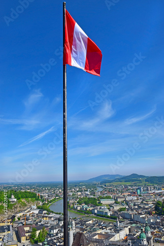 austrian national flag on the background of the panoramic view of the magnificent Salzburg, Austria