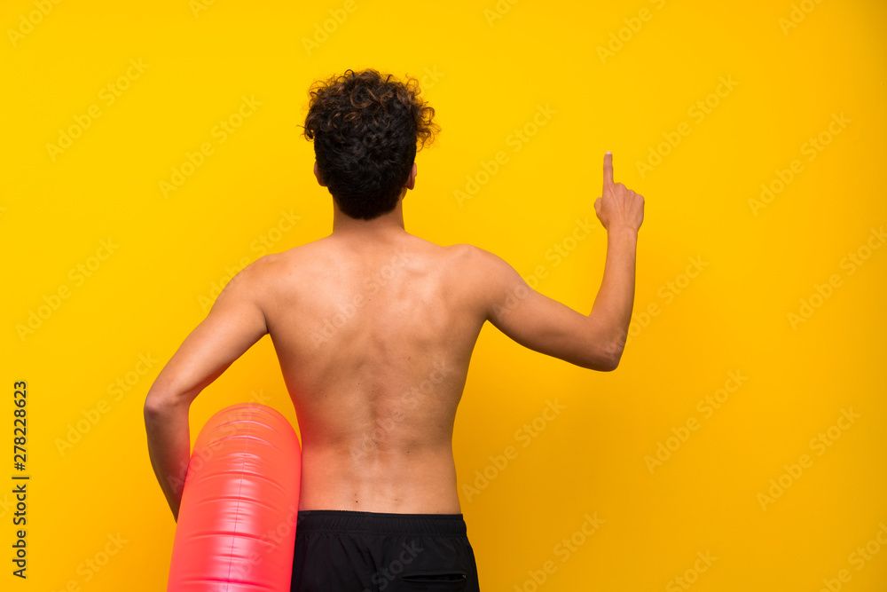 African american man over isolated purple wall pointing back with the index finger African american man over isolated purple wall pointing back with the index finger
