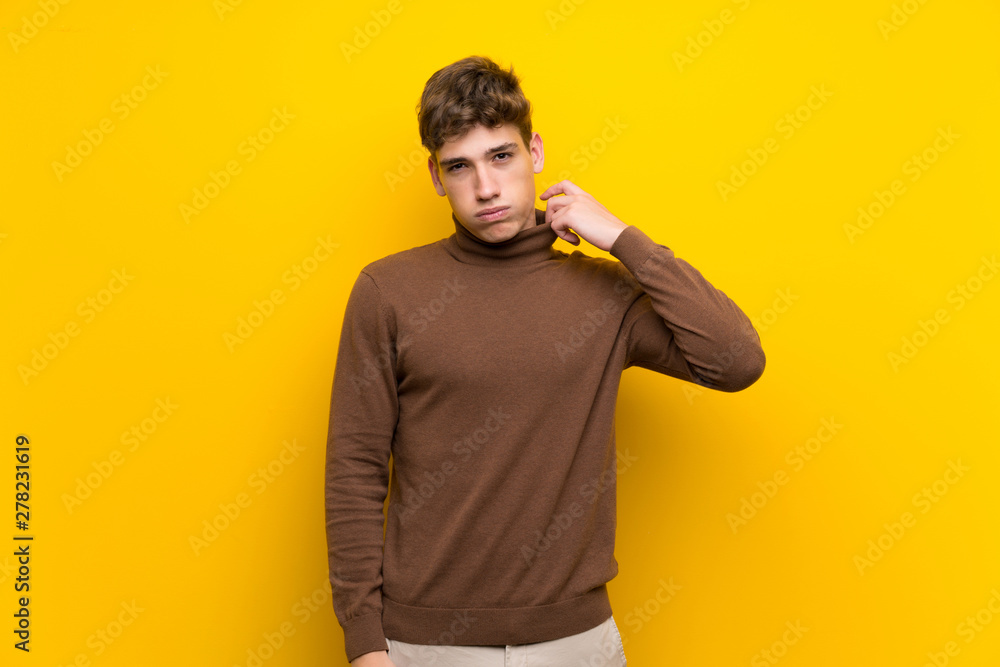 Handsome young man over isolated yellow background with tired and sick expression Handsome young man over isolated yellow background with tired and sick expression