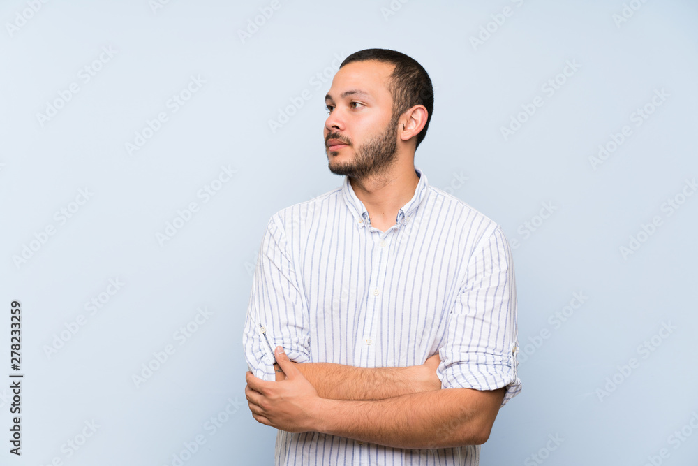 Obraz premium Colombian man over isolated blue wall portrait