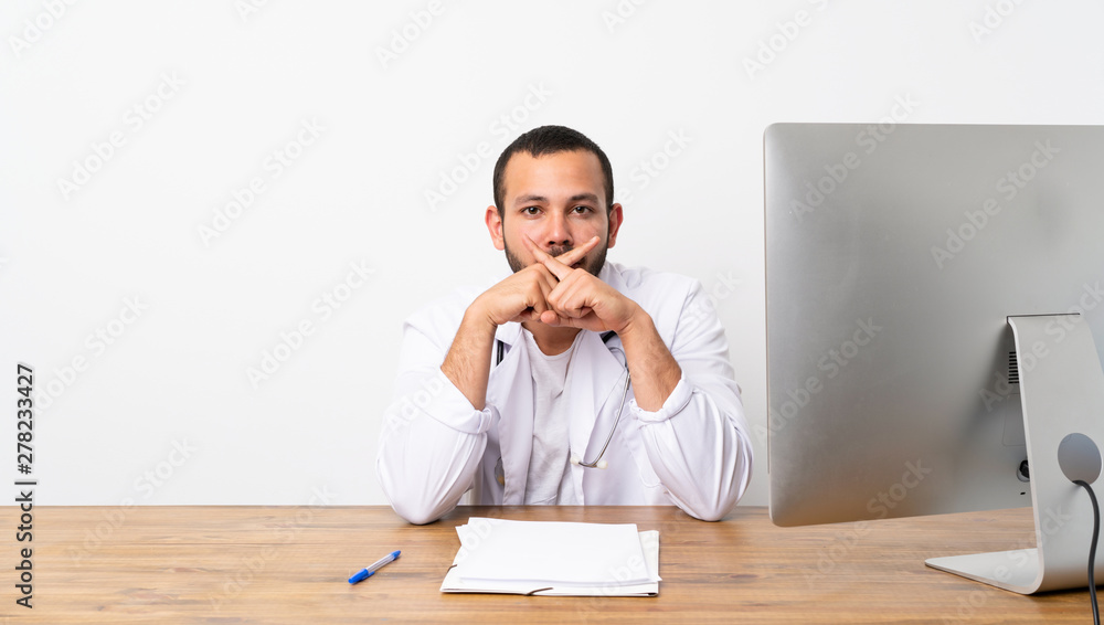 Doctor Colombian man showing a sign of silence gesture Doctor Colombian man showing a sign of silence gesture