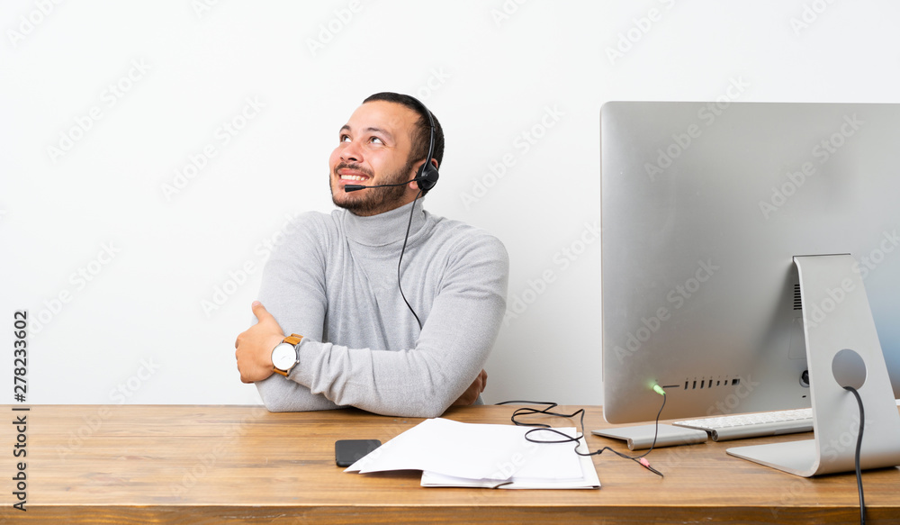 Telemarketer Colombian man looking up while smiling Telemarketer Colombian man looking up while smiling