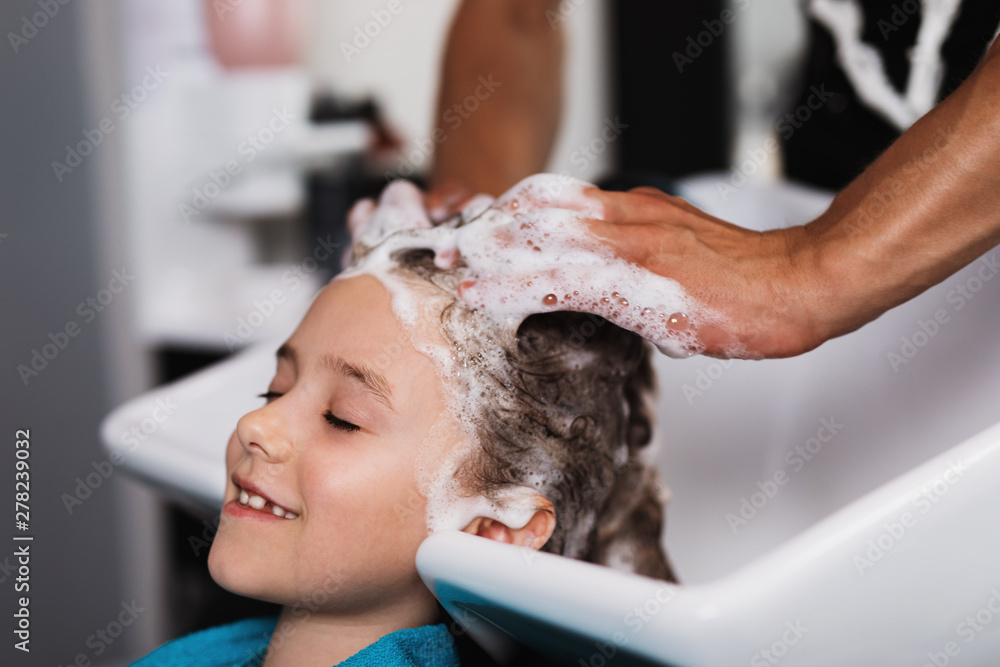 Hairdresser washing hair of cute girl in hair salon. Stock Photo | Adobe  Stock