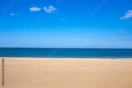 White sandy beach with ocean and deep blue sky in North Wales UK