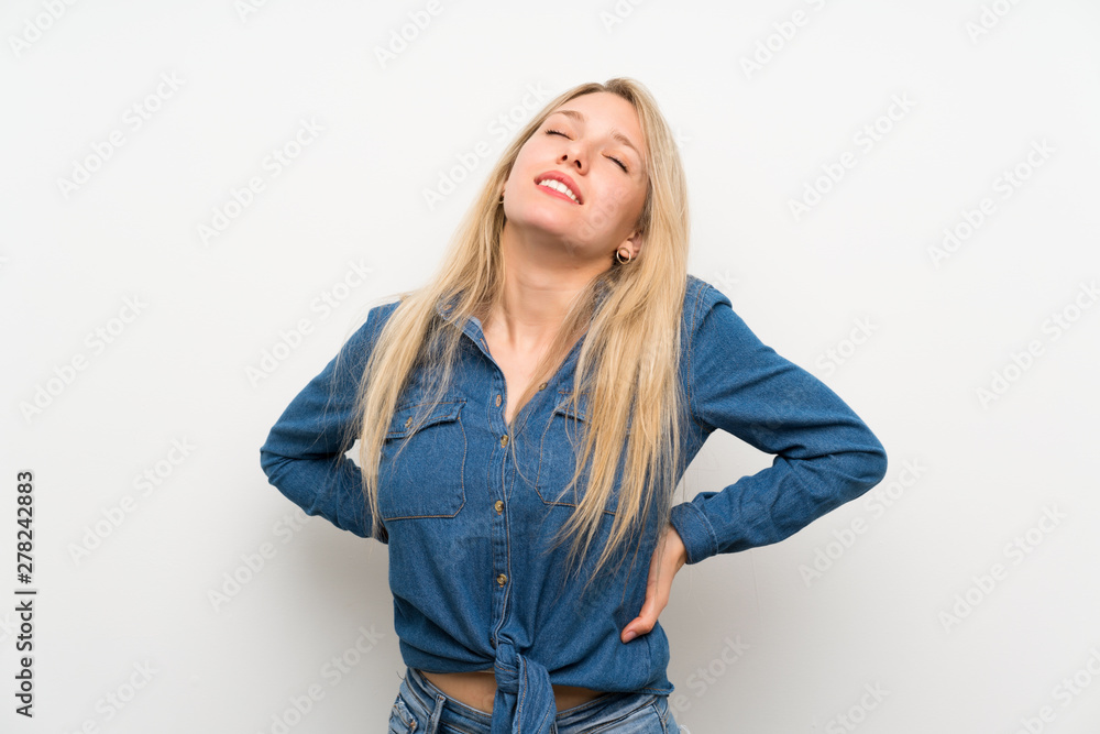 Young blonde woman over isolated white wall suffering from backache for having made an effort Young blonde woman over isolated white wall suffering from backache for having made an effort