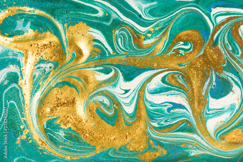Liquid uneven green marbling pattern with golden glitter and glare of light