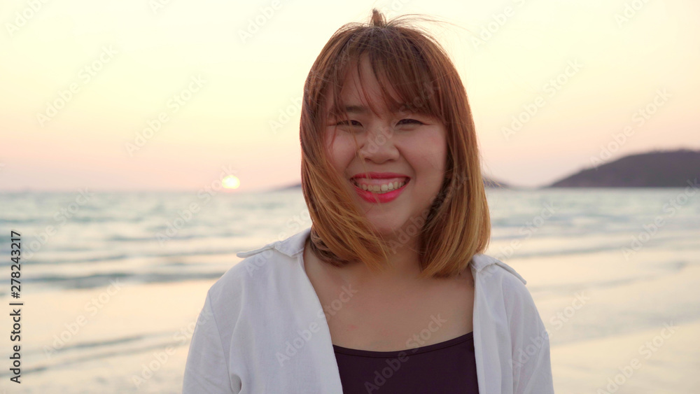 Young Asian woman feeling happy on beach, beautiful female happy relax smiling fun on beach near sea when sunset in evening. Lifestyle women travel on beach concept. Young Asian woman feeling happy on beach, beautiful female happy relax smiling fun on beach near sea when sunset in evening. Lifestyle women travel on beach concept.
