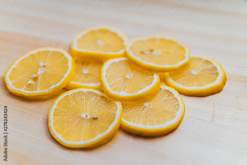 fresh lemon thinly sliced over wood with a white background fresh lemon thinly sliced over wood with a white background