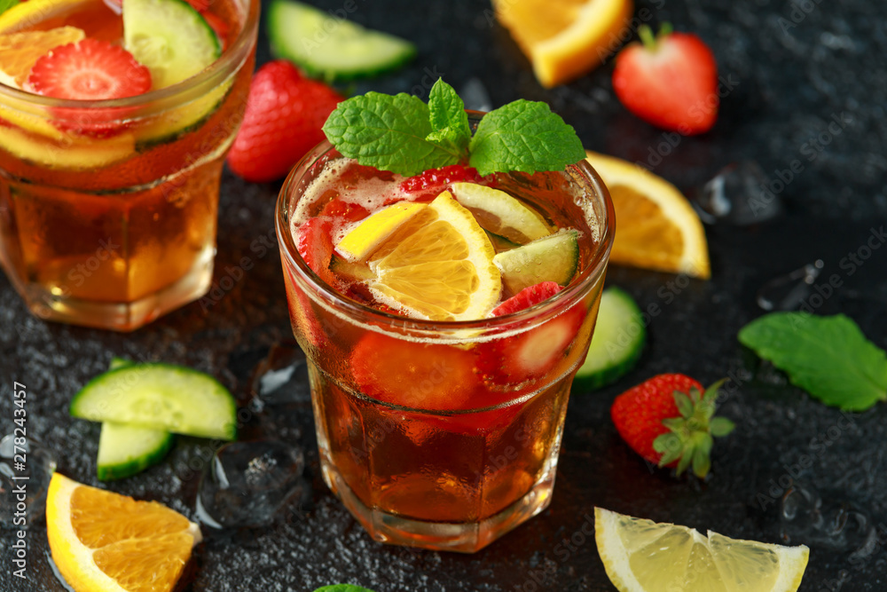 Refreshing Pimms Cocktail with Fruit and vegetables on rustic black table Refreshing Pimms Cocktail with Fruit and vegetables on rustic black table