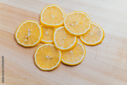 fresh lemon thinly sliced over wood with a white background
