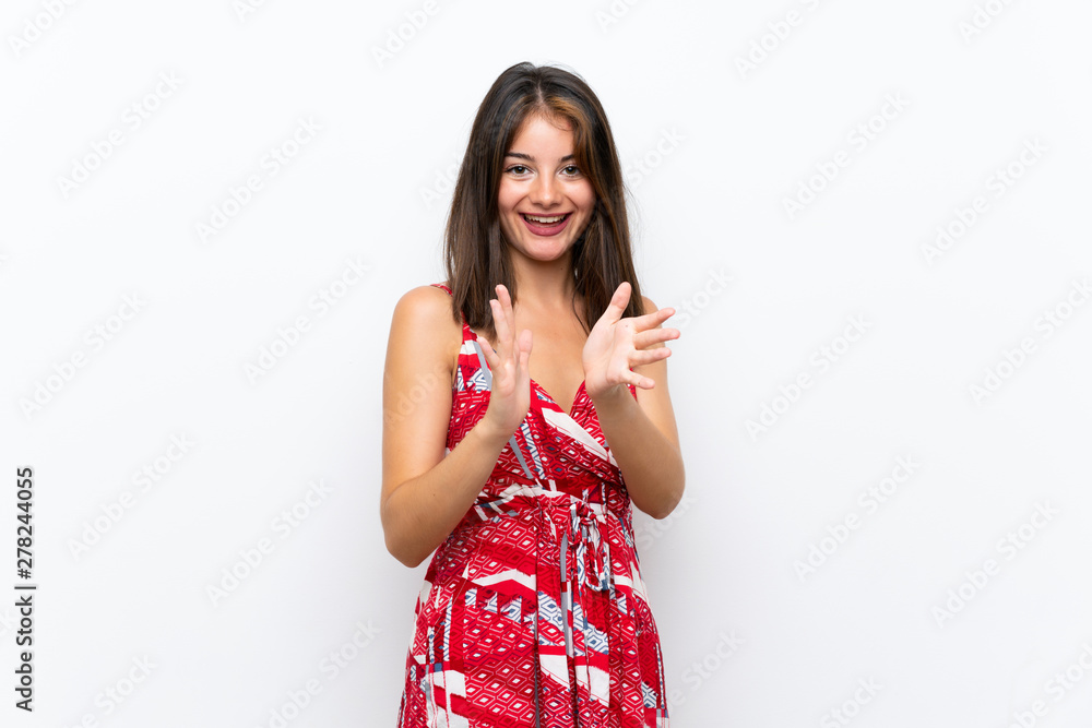 Caucasian girl in red dress over isolated white wall applauding after presentation in a conference Caucasian girl in red dress over isolated white wall applauding after presentation in a conference