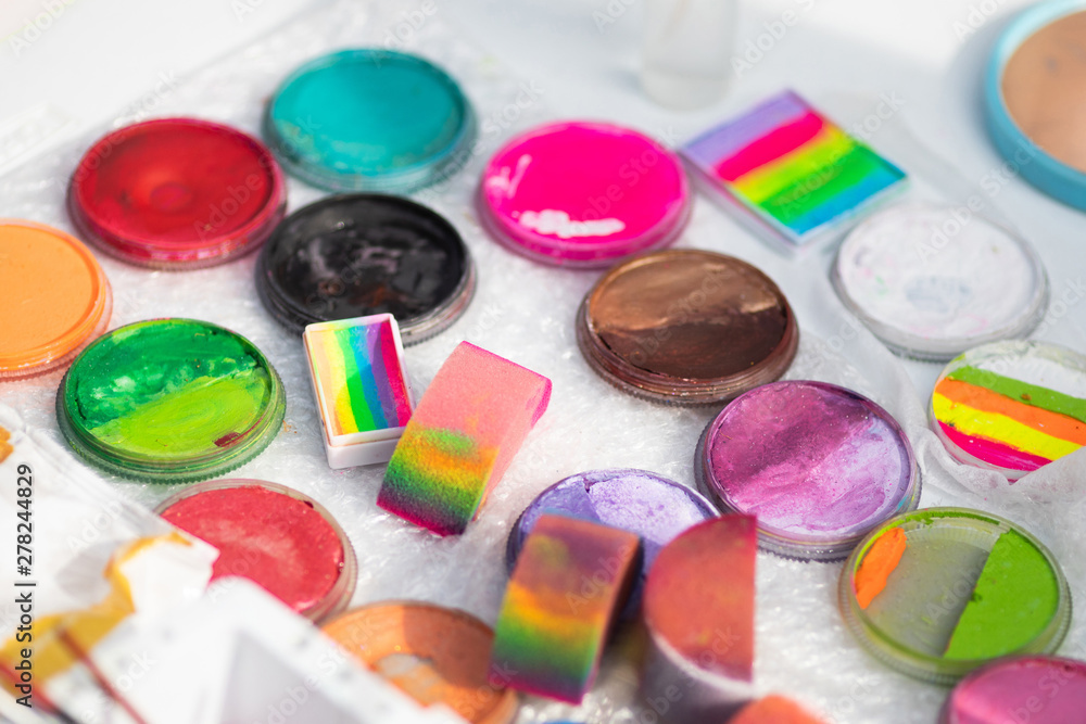 An artist's selection of face and body paint coloring materials set up on a  table. Paints for face art. Close up, top view Stock Photo | Adobe Stock