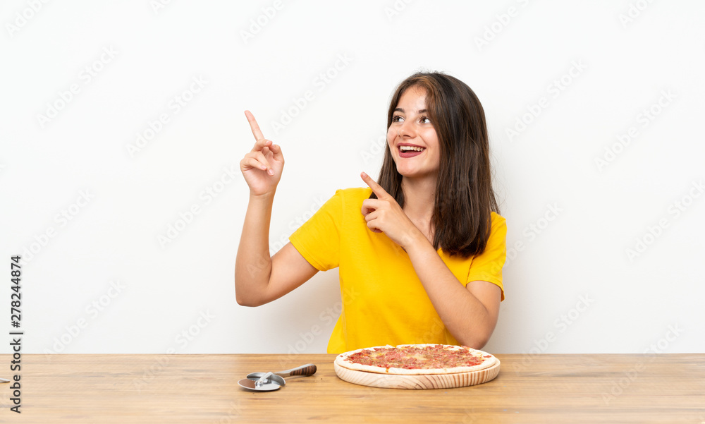 Caucasian girl with a pizza pointing with the index finger a great idea Caucasian girl with a pizza pointing with the index finger a great idea