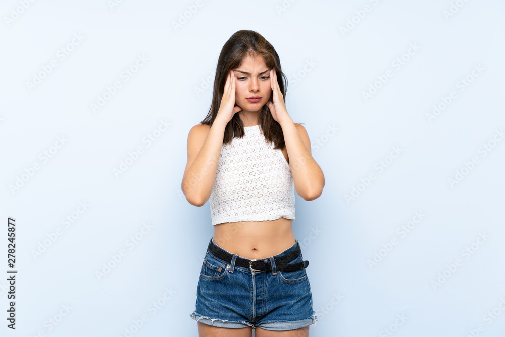 Young woman over isolated blue background with headache Young woman over isolated blue background with headache