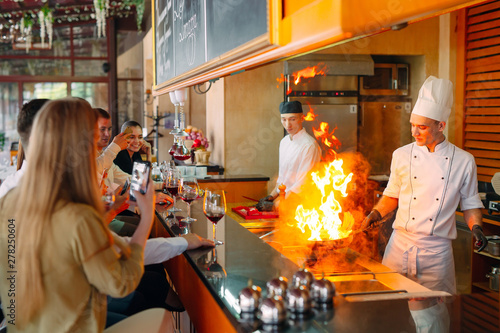 The chef prepares food in front of the visitors in the restaurant