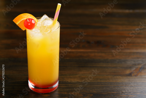 Tequila sunrise in collins glasses garnished with orange slice and cherry