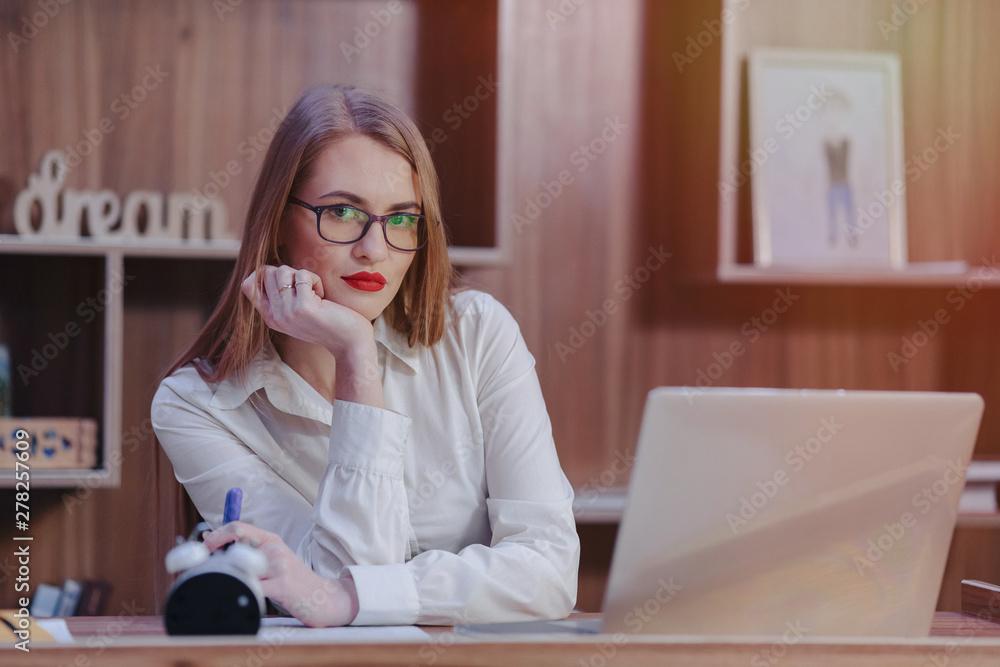 Stylish woman works at a laptop desk in a modern office Stylish woman works at a laptop desk in a modern office