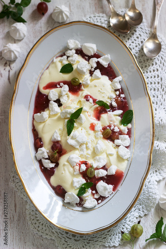 Eton mess, traditional English dessert with gooseberry, whipped cream and meringue on a light background. Rustic style. photo