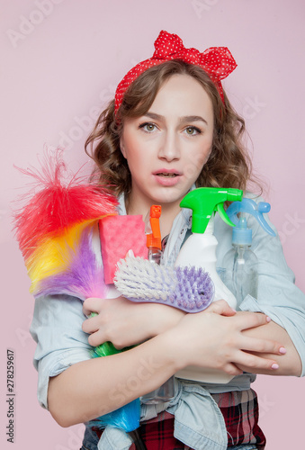 Foto Beautiful young woman with pin-up make-up and hairstyle with cleaning tools on p