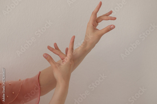 Hands of a woman dancing flamenco dance on a white background.