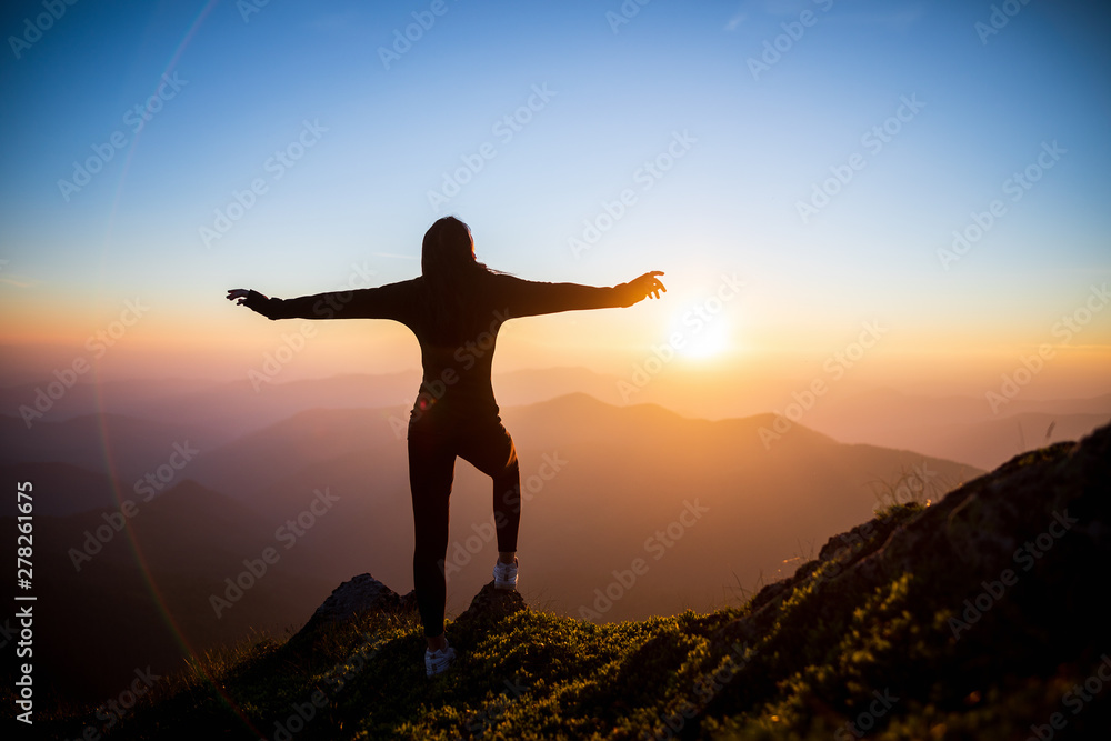 Woman hiker open arms at mountain peak. Girl on the background of mountain peaks. Woman hiking in mountains