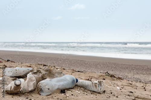 Beach pollution. Plastic bottles and other trash on sea beach